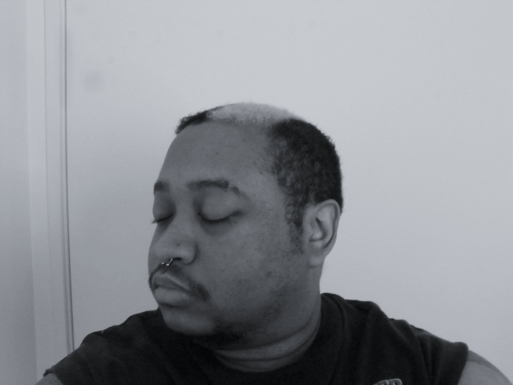 Self taken image of artist in black and white with eyes closed.
